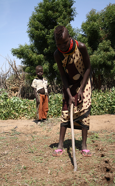 Rose, a married girl who works in the garden of the village of Vangagetei, uses a tool fashioned from a tree branch to prepare a plot for seed sowing, Turkana, Kenya, Jan. 14, 2013.  (Lindsey Welling)