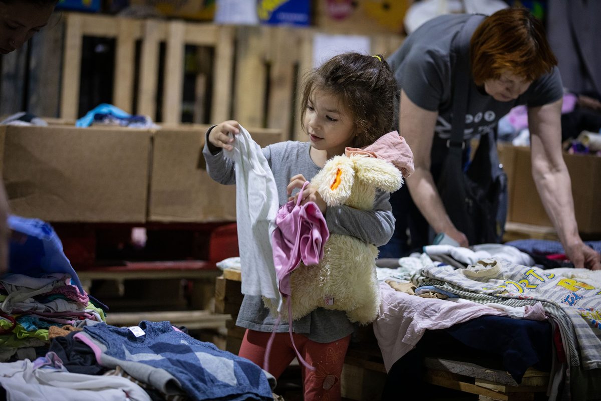A Ukrainian girl finds clothes and toys at a help center run by Moldova for Peace. 
