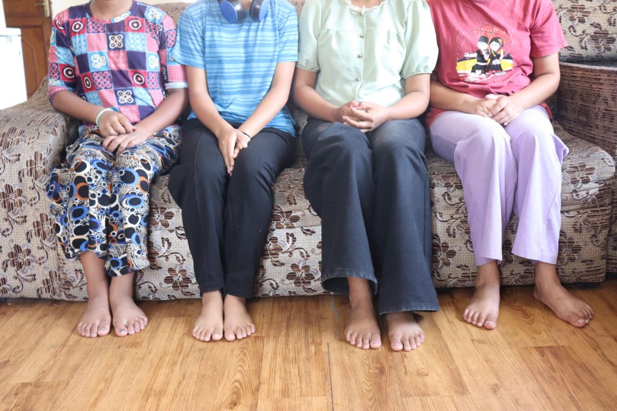 Four girls sitting in the living room of their shelter home run by Nepalese Home in Kathmandu. Photo by Rafael Cruvinel.