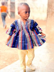 A young boy proudly wearing fugu, a timeless attire for all ages and sizes.